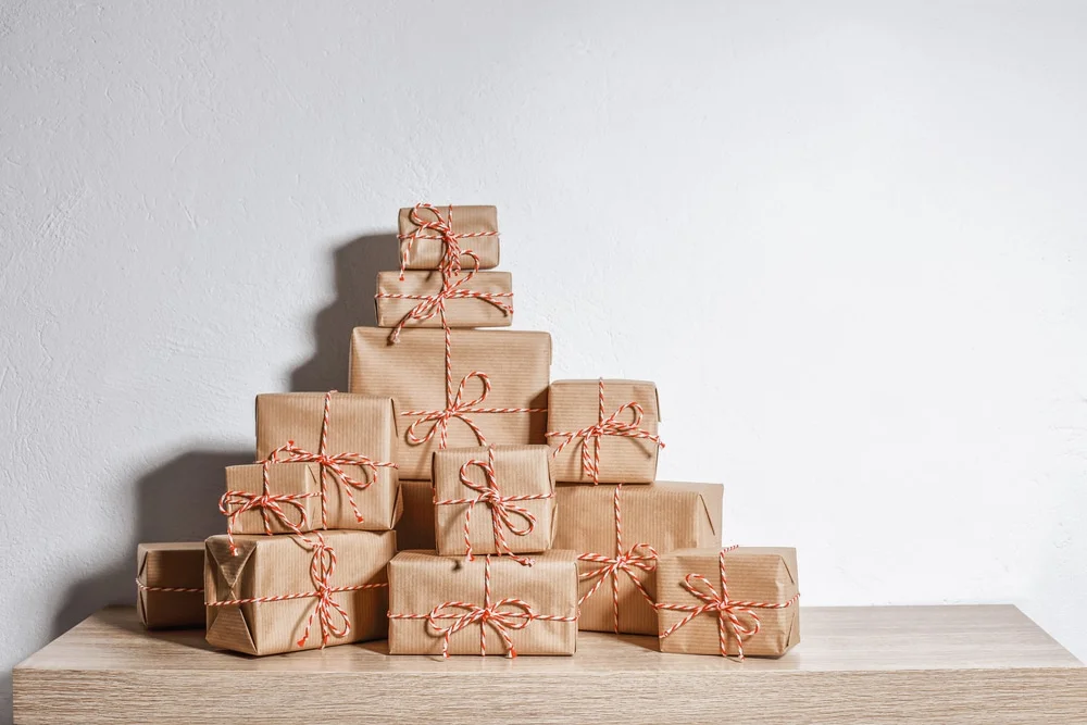 A,Pile,Of,Christmas,Gifts,Wrapped,In,Rustic,Paper,Against